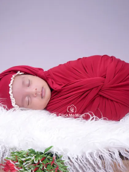 A close-up portrait from the Christmas session, focusing on the baby's serene face and the soft textures of the swaddle and hat.