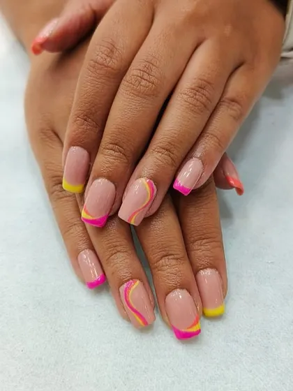 Fun and vibrant nail art perfect for summer. This design features a nude base with playful pink and yellow French tips and abstract swirls, showcasing our ability to create modern and colorful looks.