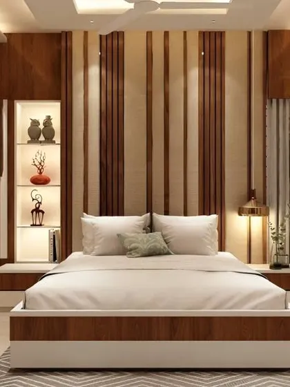 This bedroom design uses vertical wood and fabric panels to create a tall, elegant headboard wall. The built-in niche shelving with lighting is perfect for displaying small decorative items.
