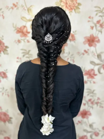 A classic fishtail braid, elevated with a silver `jhumka` accessory and scattered embellishments. I teach how to make traditional styles feel modern and fresh.