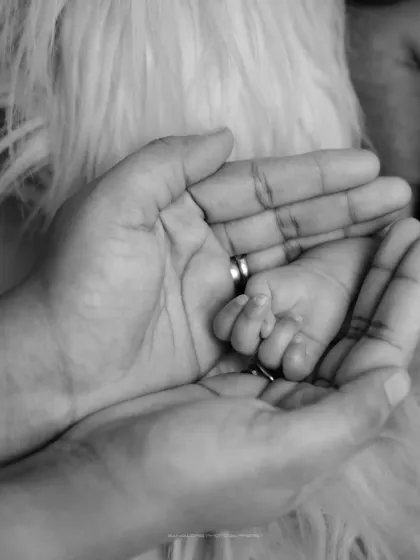 A parent's promise. This close-up, black and white shot of a baby's hand in their parent's is a simple, yet profoundly artistic, symbol of connection.