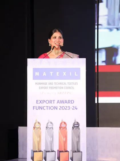 A confident posture at the MATEXIL Export Awards, ready to announce the next category of winners.