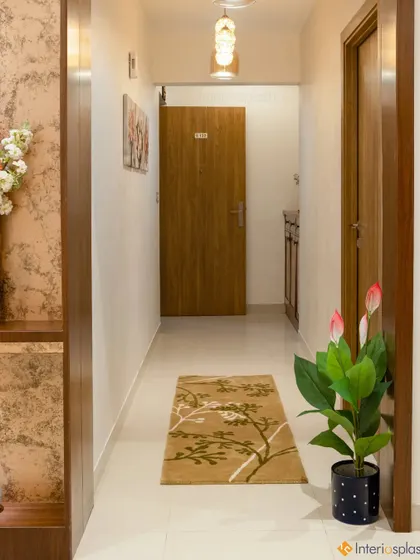A simple and elegant hallway with a floral-patterned runner, wooden doors, and a potted plant. The design feels warm and inviting.