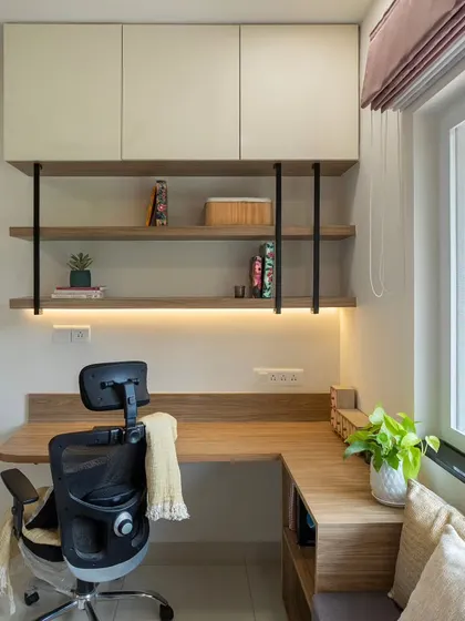 The overhead cabinets and open shelving in this home office provide ample storage for books and supplies. The combination of closed and open units keeps the space organized and visually light.