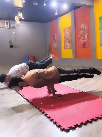 Two students practice the Mayurasana (Peacock Pose), an advanced calisthenics posture that requires significant strength and balance. This shows the level of skill my dedicated students can achieve through consistent training.