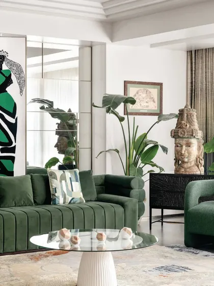 Green is a color of life and tranquility. In this living room, I used a rich green velvet sofa as the centerpiece, complemented by indoor plants and a striking stone sculpture. The mirrored wall adds depth and reflects the greenery, making the space feel larger and more open.