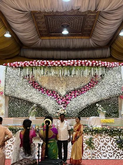 A full view of the grand floral heart stage, showcasing its scale within the wedding hall. The design ensures the couple is framed beautifully for all their photos and interactions.