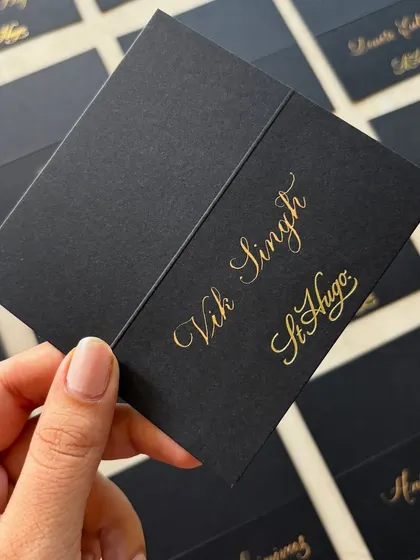 Timeless copperplate calligraphy place cards for a St. Hugo Wines sit-down event at The Ritz-Carlton, Bangalore. These personalized gold-on-black cards added an elevated, formal touch to the gathering.