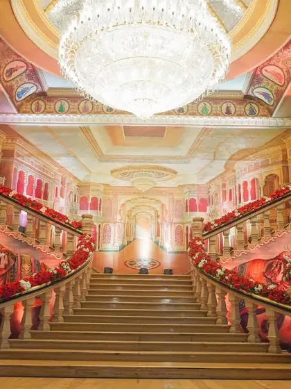 I transformed this palace venue by decorating the grand staircase with rich red florals, creating a breathtaking pathway. The combination of the venue's architecture, a massive crystal chandelier, and my decor work resulted in an atmosphere of pure royalty.