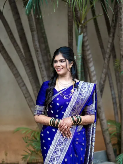 A classic three-quarter portrait of the bride, highlighting her elegant posture and the beautiful details of her saree and simple jewelry.