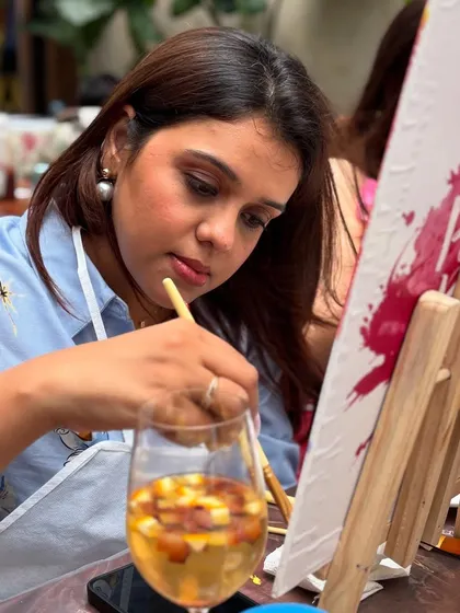 A close-up of a guest enjoying a glass of wine while adding details to her painting. My workshops are designed to be relaxing, just like a paint and sip night with friends.