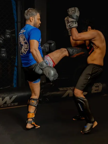 A fighter practices a body kick during a sparring drill, showing the importance of proper defense.