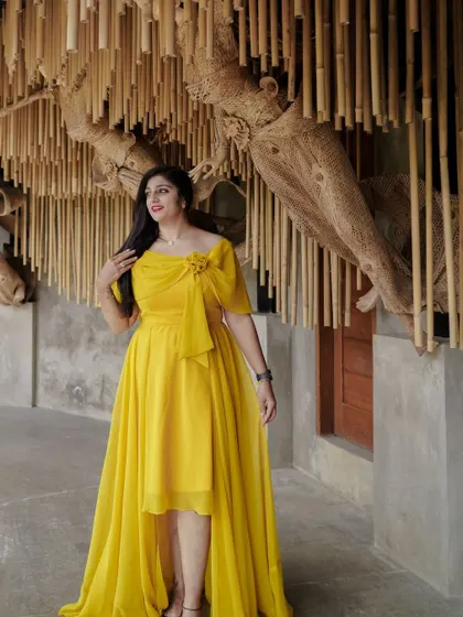 A client looking radiant in a custom-designed yellow high-low gown, perfect for a pre-wedding shoot.