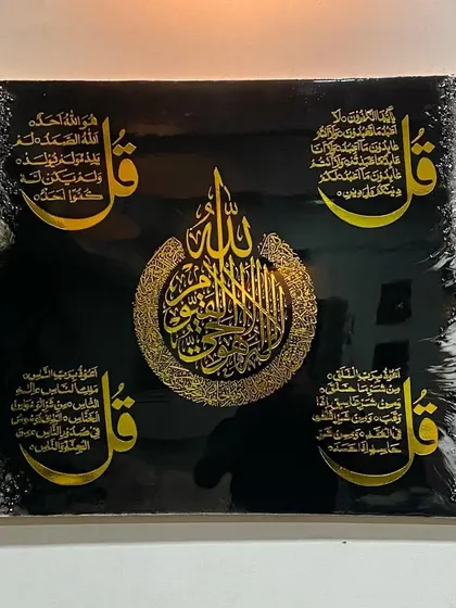 A powerful piece combining Ayat al-Kursi and the Four Quls on a black background. The central calligraphy is surrounded by the four verses, creating a balanced and protective artwork.