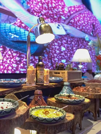 A beautifully arranged Middle Eastern mezze station, featuring a variety of dips and salads in colourful tagines and bowls. This setup offers a journey through the rich flavours of the Levant.