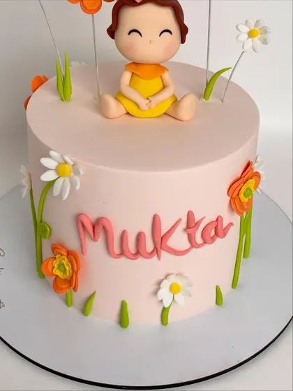 Another angle of Mukta's birthday cake, showing the placement of the flowers and the personalized name in a playful font.