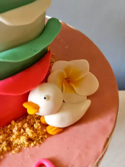 A cute, tiny detail from the Stitch cake: a little edible duckling sitting amongst the flowers and "sand" made from crushed biscuits.