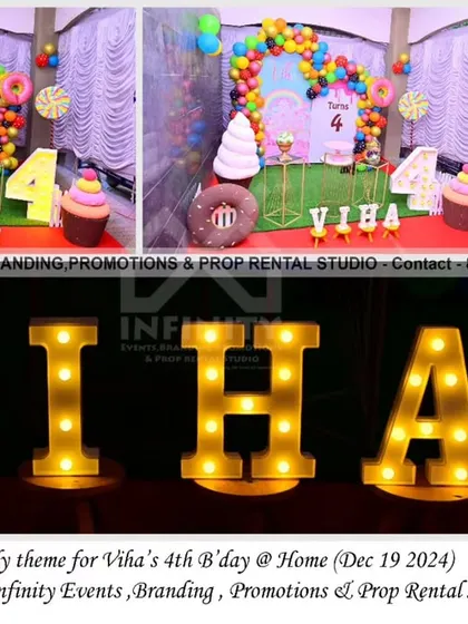 This simple and elegant candy theme for a 4th birthday at home features a semi-arch backdrop with a colorful balloon garland and giant candy props. The marquee letters add a bright and festive touch to the sweet setup.