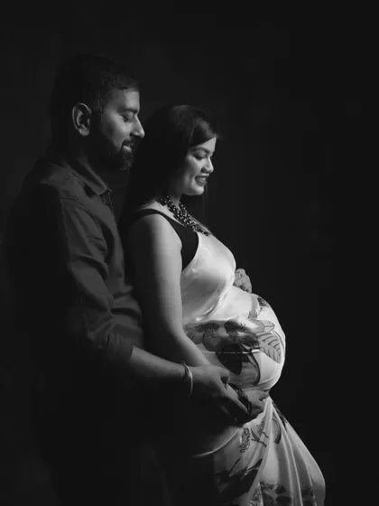 A classic black and white maternity photo of a couple, capturing the intimacy and anticipation of their journey to parenthood.