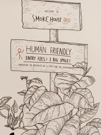 A close up of the hand drawn mural at Smoke House Deli, featuring a welcoming sign. The detailed line work is characteristic of this signature style.