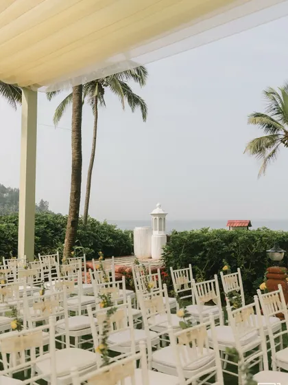 A wide view of the guest seating for the seaside Haldi, with white chairs looking out towards the ocean.