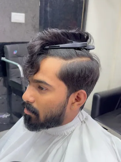 Sectioning the hair is the first step to creating a structured haircut like this side-parted style. It ensures the final cut is balanced and precise.