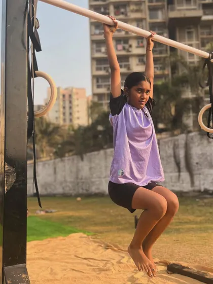 This young athlete is focused on her hanging knee tucks, an excellent exercise for developing core and grip strength.
