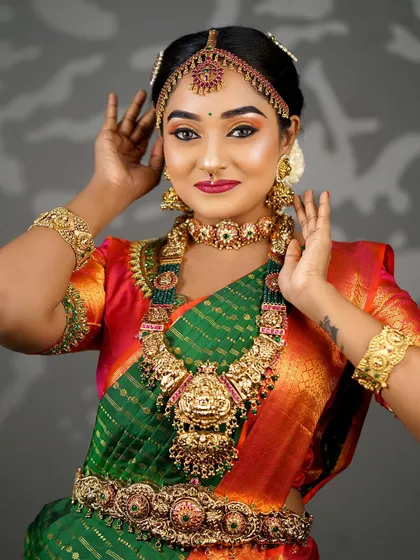 A classic portrait showcasing the bride's full attire and jewellery. The makeup is balanced to complement the grandeur of the overall look.