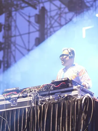 Surrounded by stage smoke and spotlights, I'm fully immersed in the music. This image shows me at my DJ console during a major concert, showcasing the professional setup and atmosphere of my live performances.