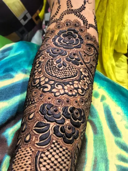 A close-up of the incredible detail in this bridal sleeve, featuring checkerboard fills and bold rose motifs.