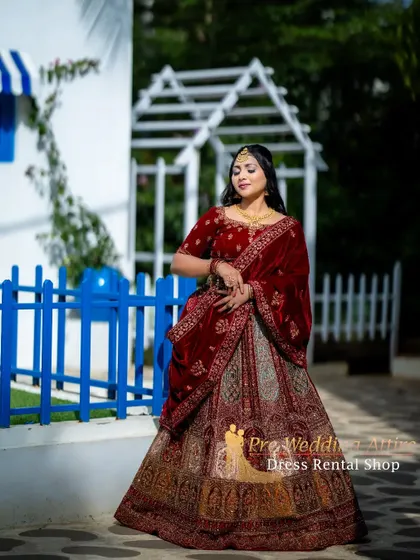 A side view of the red velvet lehenga, showcasing the intricate patterns and the volume of the skirt.
