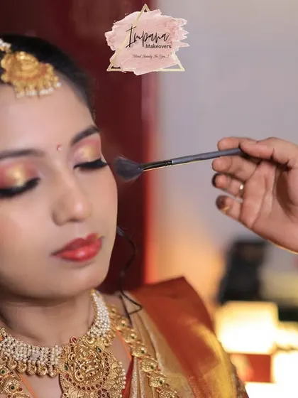 The final touch. Here, I am applying a soft powder to set this bride's Muhurtham makeup. This action shot captures the precision and care I put into creating a look with glowing skin and captivating eyes that feels both special and comfortable.