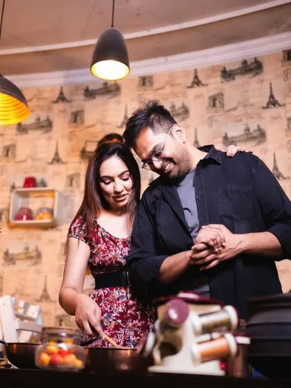 A quiet, affectionate moment during their cooking-themed pre-wedding shoot. Her hand on his shoulder and their gentle smiles speak volumes about their supportive partnership.