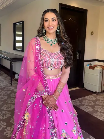 This Mehendi look was all about soft makeup and stunning pink hues. The mirror-work lehenga is balanced with a gentle glam that lets the bride's happiness shine.