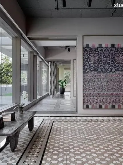 The FCML showroom in Pune was designed to be "extroverted," consciously connecting with its environment. Expansive glazing bathes the tile displays in natural light, while the interior layout frames views of a large tree, making it a sculptural element within the design.
