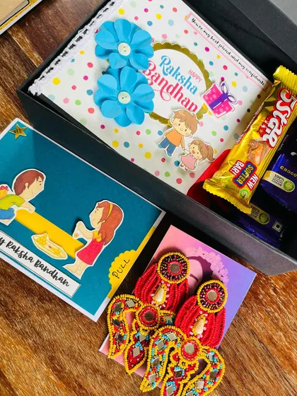 This curated Rakhi hamper features a pair of our elegant red mirror-work earrings, making it a stylish and personal gift for a sister.