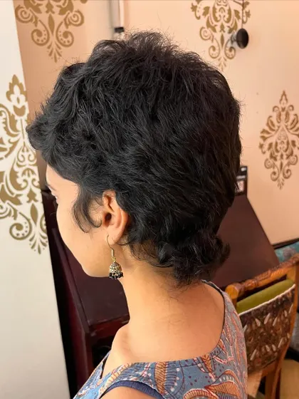Another angle of Aditi's curly mullet, showcasing its texture.