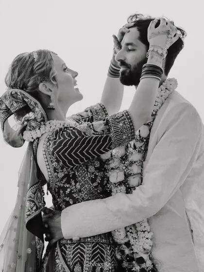 A playful, candid black and white moment from a beach wedding.