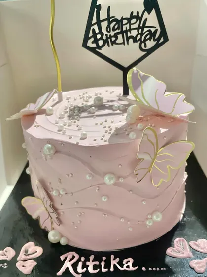 A lovely pink butterfly cake that's perfect for birthdays. The soft pink frosting is decorated with graceful butterflies and edible pearls, creating a delicate and feminine design.