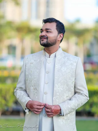 A handsome outdoor portrait of the groom in his elegant off-white engagement attire.