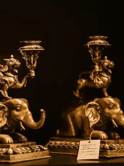 A sepia-toned shot of the elephant and lion brass candle holders. This image highlights their vintage appeal and the intricate craftsmanship that makes them a favorite among collectors and designers.