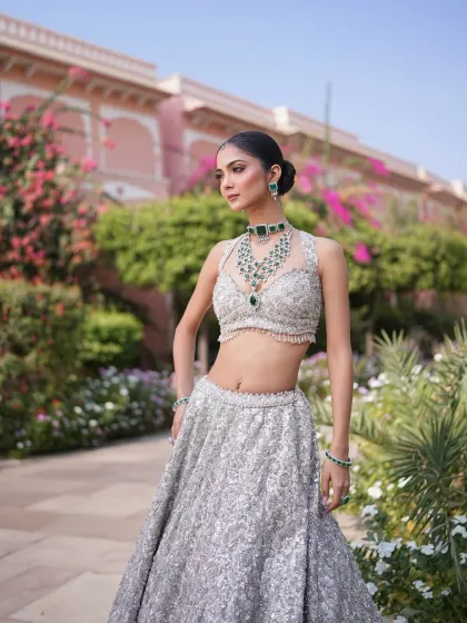 Dripping in elegance and luxury. A silver sequined lehenga paired with a stunning emerald necklace for a pop of color.