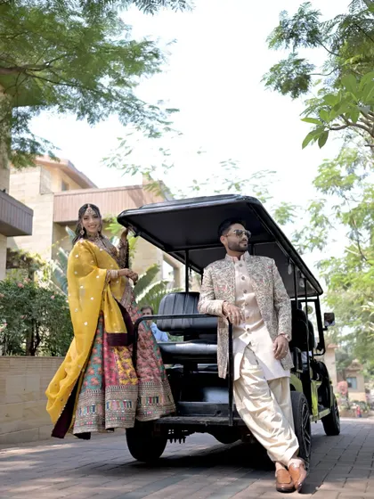The couple strikes a pose with a golf cart, a fun and candid moment from their Mehndi day that shows their playful personalities.