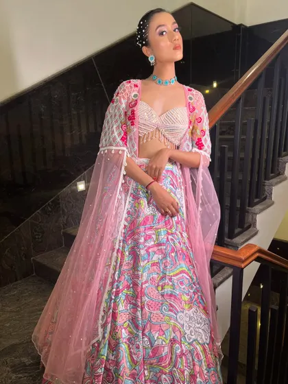 The complete look with a sheer pink cape, adding a layer of modern style to the printed lehenga.
