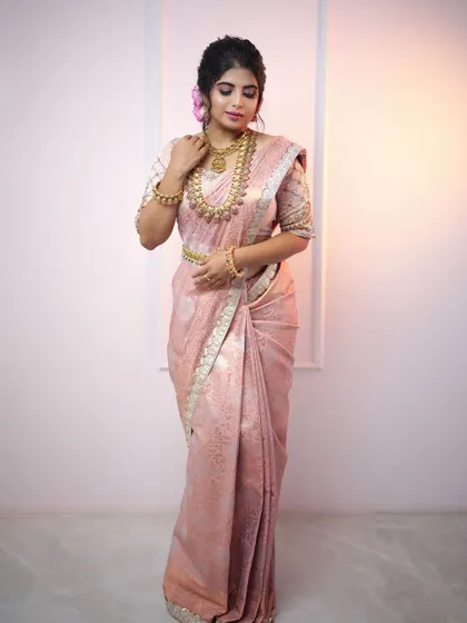 A soft pink silk saree that exudes grace and elegance. This outfit is perfect for an engagement ceremony or a daytime wedding event, offering a subtle yet beautiful bridal option.