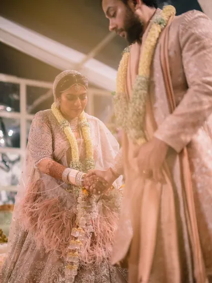 The moment of Jaimala under a shower of petals. The contemporary mirrored mandap reflects the joy of the couple and their families, making the moment even more spectacular.