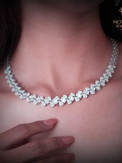 A classic diamond necklace with a delicate, leaf-like pattern. This is a versatile and timeless piece, perfect for adding a touch of sparkle to both formal and casual attire.