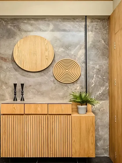 This entryway shoe cabinet features fluted wooden doors and circular wall art. The minimalist design provides stylish, concealed storage for a clutter-free entrance.