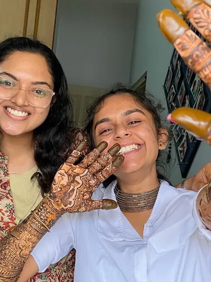 Capturing the joy and excitement of a bride-to-be showing off her freshly applied, intricate mehndi.