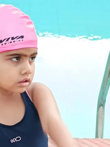 A young swimmer's focused expression before starting her lesson, ready to dive in and learn.